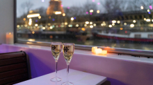 Two glasses of champagne on board an aperitif cruise in Paris, with a view of the Eiffel Tower in the background