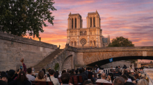 Cathédrale Notre-Dame de Paris au coucher du soleil vue depuis un bateau de croisière sur la Seine avec des passagers à bord