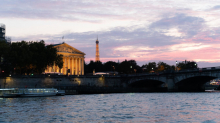 Tour Eiffel et Palais Bourbon au coucher du soleil vus depuis la Seine avec un bateau de croisière à Paris