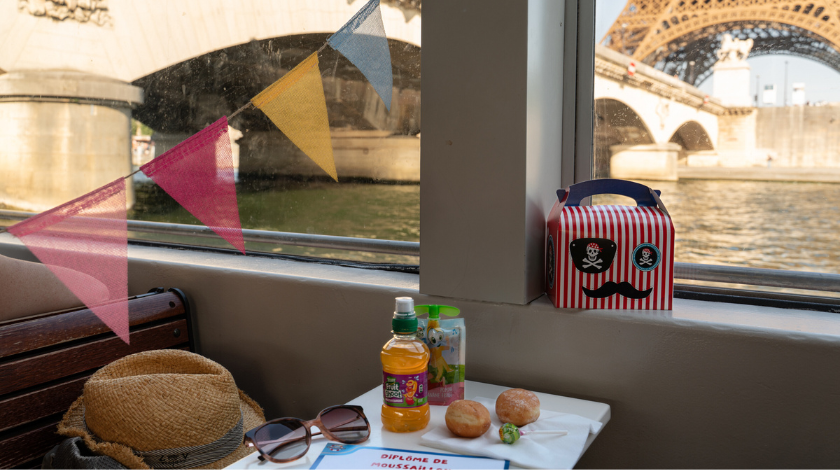 Goûter enfant à bord d’un bateau-mouche lors d’une croisière touristique sur la Seine à Paris avec vue sur la tour Eiffel