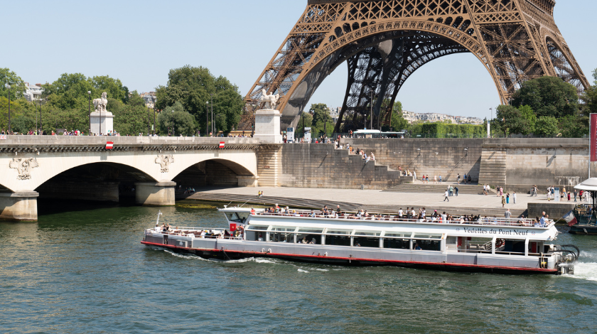 Bateau-mouche en croisière touristique sur la Seine à Paris passant devant la tour Eiffel