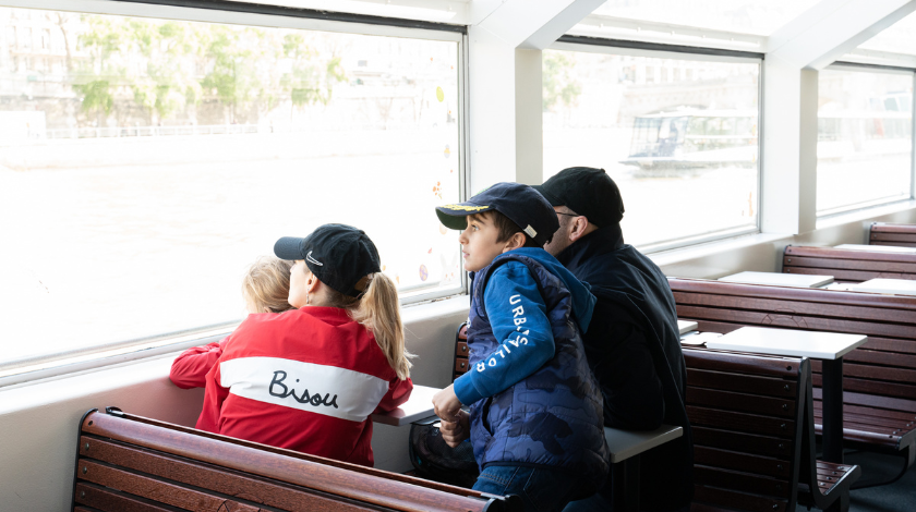Famille avec enfants à bord d’un bateau-mouche lors d’une croisière touristique sur la Seine à Paris