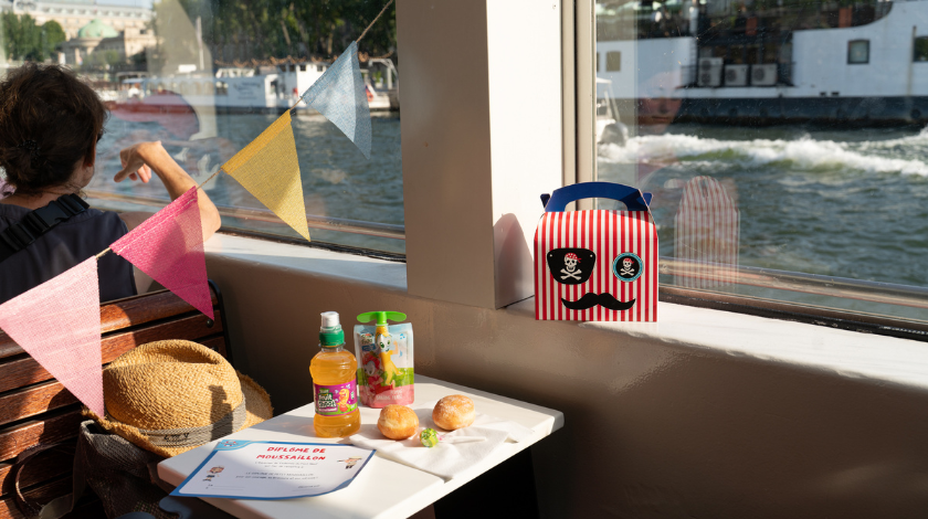 Guide conférencier animant une croisière touristique sur la Seine à Paris à bord d’un bateau-mouche avec passagers