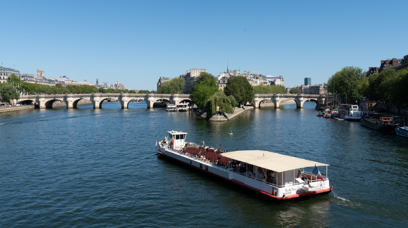 Bateau-mouche en croisière touristique sur la Seine à Paris près du Pont Neuf avec vue panoramique sur la ville