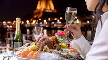 Seafood platter and glass of champagne with Eiffel Tower lit up in the background