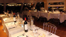 Nighttime boat restaurant with set tables and wine bottles