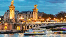 Cruise boat sailing past the illuminated Pont Alexandre III