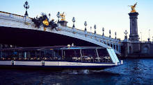 Le Grand Pavois boat cruising past Pont Alexandre III at dusk