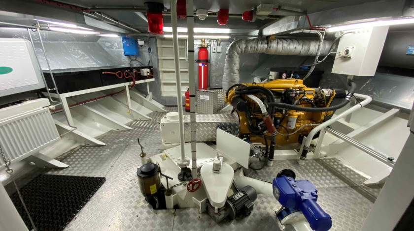 Engine room of the Lutécia boat with yellow diesel engine, electrical panels and technical equipment, visited during European Heritage Days in Paris