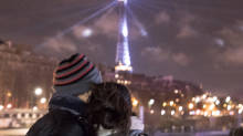 Couple admirant la Tour Eiffel illuminée pendant une soirée romantique à Paris