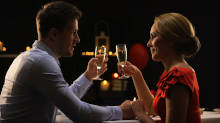 Pareja brindando con champán durante una cena de San Valentín