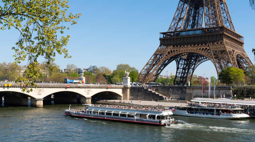 Vedettes du Pont Neuf sightseeing boat cruising on the Seine near the Pont d’Iéna and the Eiffel Tower in Paris