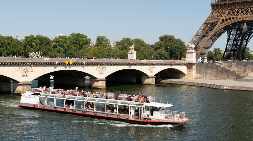 Vue panoramique sur la Seine depuis l’arrière du bateau avec passagers en croisière à Paris