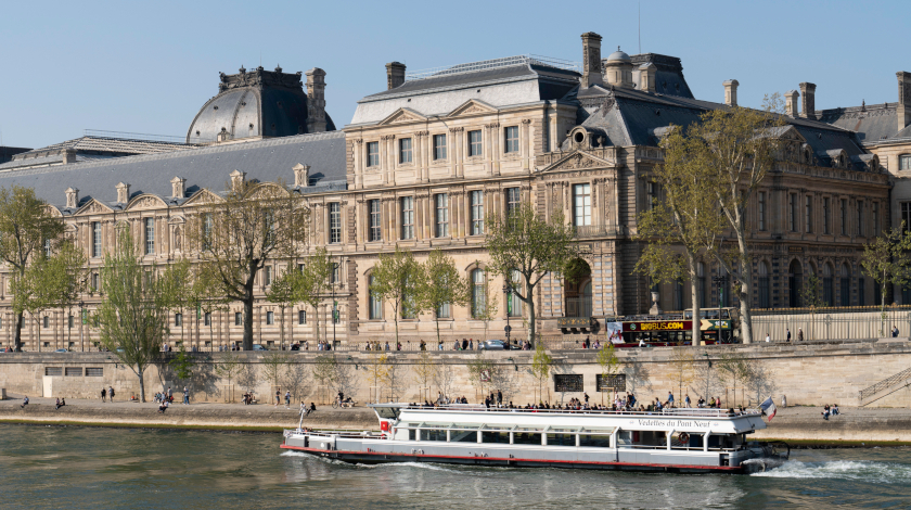 Bateau de croisière sur la Seine passant devant le musée du Louvre à Paris