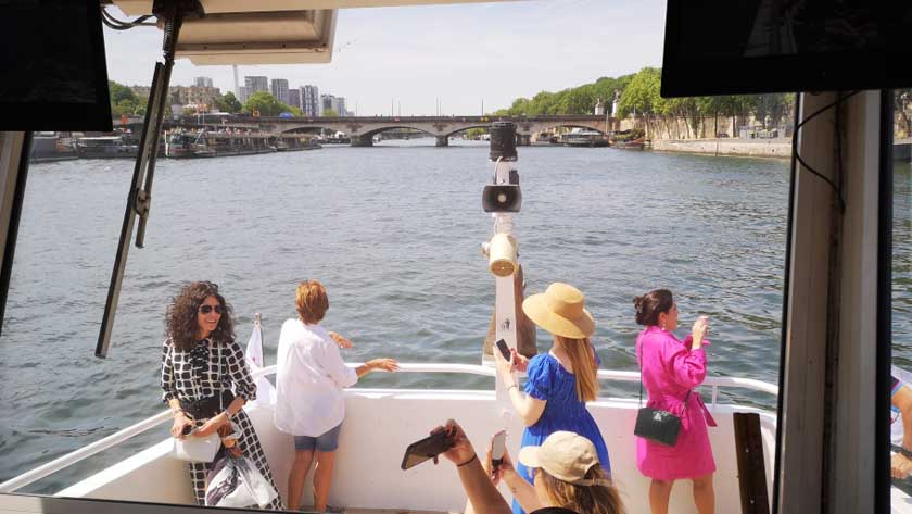 Passengers enjoying the view of the Seine from the front of the boat during a cruise in Paris