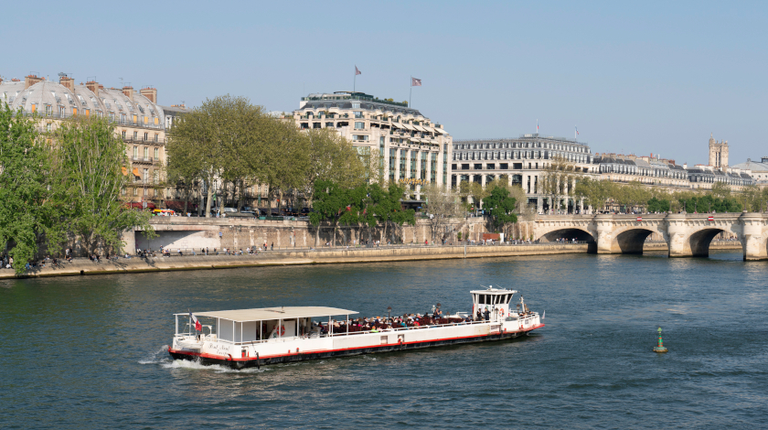 Vedettes du Pont Neuf boat cruising on the Seine with a view of La Samaritaine and Pont Neuf