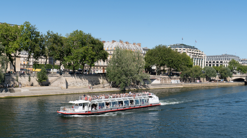 The Hydraseine boat cruising on the Seine with a view of the riverside and La Samaritaine