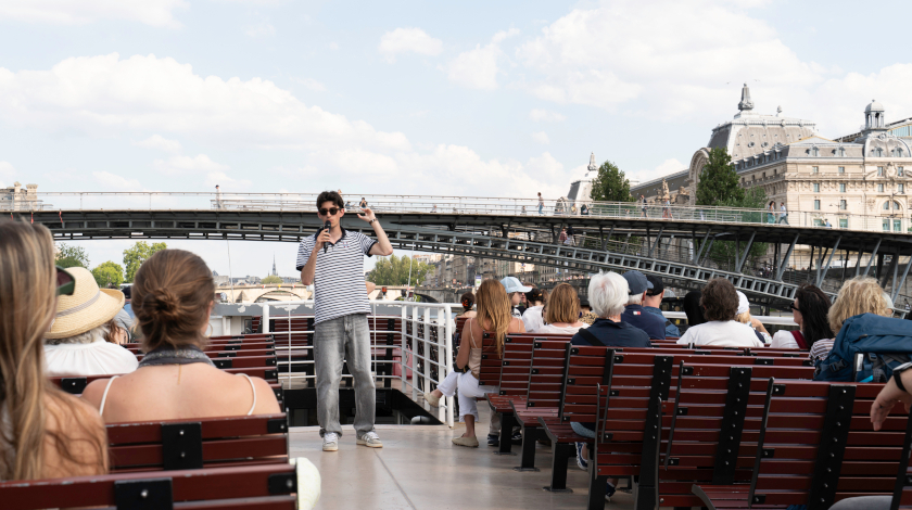 Onboard guide explaining Paris landmarks during the cruise